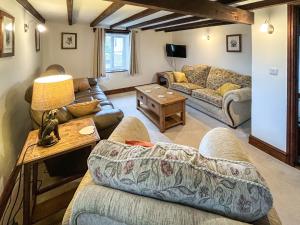 uma sala de estar com um sofá e uma mesa em Cowslip - 23653 em Bradworthy