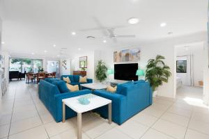 a living room with blue couches and a tv at 22 Sorrento Avenue in Coolum Beach