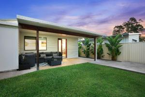 a house with a patio with a grass yard at 22 Sorrento Avenue in Coolum Beach