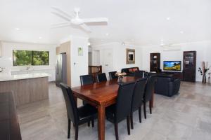 a dining room and living room with a table and chairs at 8 Springfield Avenue in Coolum Beach