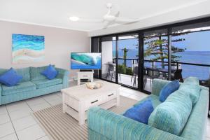 ein Wohnzimmer mit 2 blauen Sofas und einem TV in der Unterkunft Unit 5 Phoenix in Coolum Beach