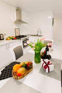 una cocina con un bol de fruta y un jarrón de flores en Black&White Нова стильна квартира на Київській en Ternopilʼ