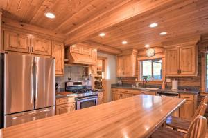 a kitchen with wooden cabinets and a stainless steel refrigerator at Brookings Vacation Rental Lodge on 88 Acres! in Brookings