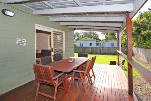 a wooden table and chairs on a deck at 24 Sundew Street in Mudjimba