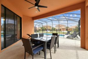 una sala da pranzo con tavolo, sedie e piscina di Large family friendly Vacation Home, Private Pool, Golf course location, Nr Orlando Disney Parks Florida a Davenport