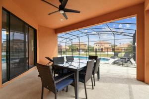 a dining room with a table and chairs and a pool at Large family friendly Vacation Home, Private Pool, Golf course location, Nr Orlando Disney Parks Florida in Davenport
