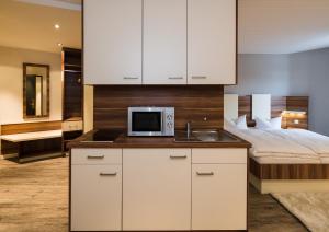 una cucina con lavandino e un letto in una camera di Central Hotel-Apart München a Monaco