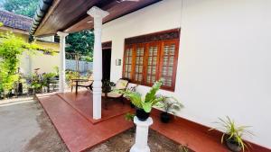 un portico di una casa con panchina e tavolo di Allan Villa a Midigama East