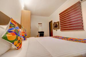 a bedroom with a large white bed with a window at FabHotel Royal Park Residency in Chennai