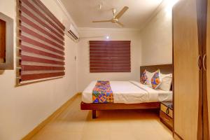 um quarto com uma cama e uma ventoinha de tecto em FabHotel Royal Park Residency em Chennai