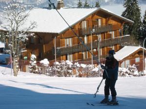 uma pessoa em esquis na neve em frente a uma cabine em Chalet Gabriel em Saint-Gervais-les-Bains