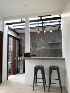 uma cozinha com dois bancos pretos num balcão em Davyn's House - Cozy and Private House in Lombok em Prampuan