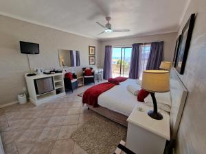 a bedroom with a bed and a living room at Glenfinnan Guest House in Langebaan