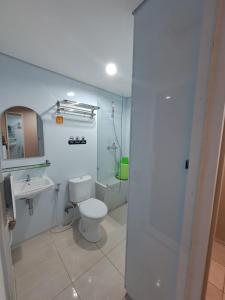 een witte badkamer met een toilet en een wastafel bij Christine Hotel Jogja in Jetis