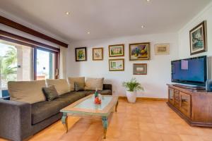 a living room with a couch and a tv at Ideal Property Mallorca - Ca na Siona 6 PAX in Alcudia