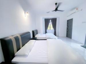 卢穆特Venice Guest Hostel - Bilik Sahaja的有三张床和一扇窗户的房间