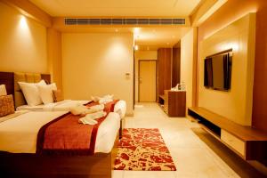 RourkelaにあるHOTEL PAHADIのベッド2台、薄型テレビが備わるホテルルームです。