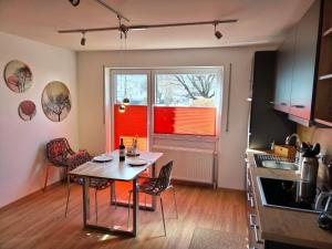 a kitchen with a table and chairs and a window at Ferienwohnung am Gänsbach in Grassau