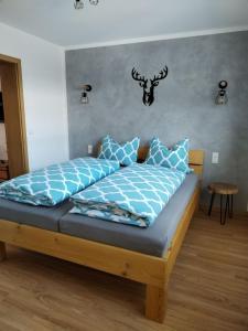 un letto con cuscini blu sopra di Ferienwohnung am Gänsbach a Grassau