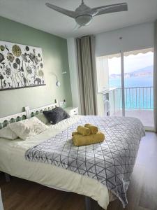 sypialnia z łóżkiem z żółtym ręcznikiem w obiekcie Portofino Mar y Sal w mieście Benidorm