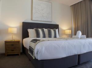 a bedroom with a large bed with two lamps at RIVERVIEWS@THECOSMOPOLITAN UNIT20805 in Maroochydore