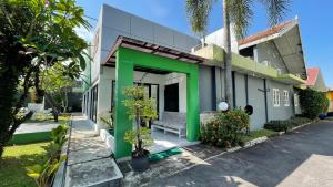 uma casa com tinta verde e branca em Planters Guest House em Yogyakarta