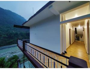 a balcony of a house with a view of a river at Hotel Aastha, Uttarkashi in Uttarkāshi