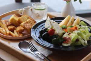 a tray of food with a plate of salad and french fries at 鴝花甜點民宿 QuHua Sweety B&B in Dongshan