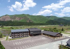 an aerial view of a building with mountains in the background at Aso Hakuun Sanso in Aso