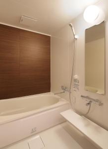 a bathroom with a bath tub and a sink at Aso Hakuun Sanso in Aso