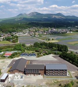 une vue aérienne d'une école avec des montagnes en arrière-plan dans l'établissement Aso Hakuun Sanso, à Aso