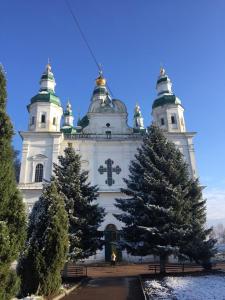 a church with two christmas trees in front of it at Апартаменты Анна in Chernihiv