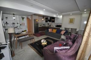 a living room with a purple couch and a kitchen at Daire Beşiktaş 3+1 in Istanbul