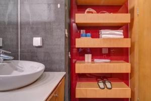 a bathroom with a white sink and a red wall at Beijing Yasmine Seasons Park Apartment Hotel in Beijing