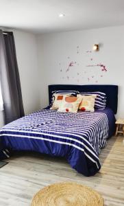 um quarto com uma cama azul e branca com almofadas em Les Gones en Vendée em Saint-Gervais