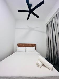 a bedroom with a bed with a black ceiling fan at Langkawi Seaview Cube w/ Rooftop Pool in Kuah