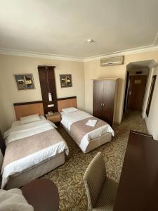 una habitación de hotel con 2 camas y una silla en Hotel Topkapı en Estambul