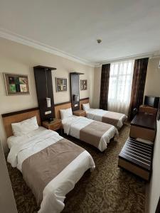 イスタンブールにあるHotel Topkapıのベッド3台とデスクが備わるホテルルームです。