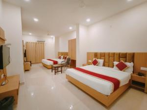 ein Hotelzimmer mit 2 Betten und einem TV in der Unterkunft Hotel Bansal Paradise near golden temple in Amritsar