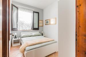 um pequeno quarto com uma cama e uma janela em Arianna's house with sea view, parking and wi-fi em Avola
