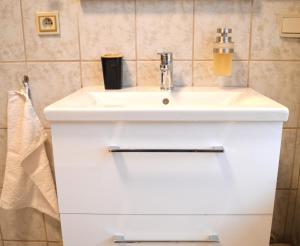 bagno con lavandino bianco e asciugamano di 4N Appartement a Eupen