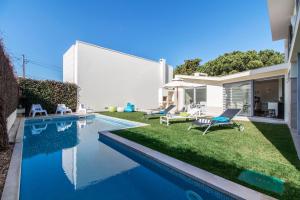 une arrière-cour avec une piscine et une maison dans l'établissement Villa do Casalinho, à Sesimbra