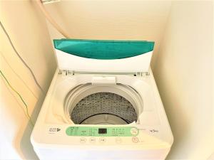 a washing machine with a green lid in a room at Credo Maison Kamakura 202 in Kamakura