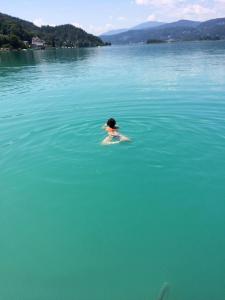 a person swimming in a large body of water at Appartment Isabelle Sky in Presseggersee