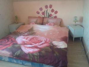 um quarto com uma cama com flores na parede em Dom Pod Różą em Leśna