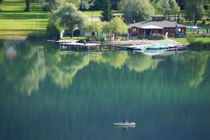 a small boat in the middle of a lake at Appartment Isabelle Sky in Presseggersee