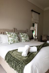 a bedroom with a bed with towels on it at Champagne Properties, Porterfield Estate in Champagne Valley