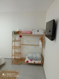 a room with a bunk bed and a television at פסגת הדרור in Shelomi