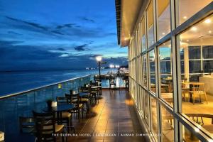 uma varanda com mesas e cadeiras num navio de cruzeiro em The Elopura Hotel em Sandakan