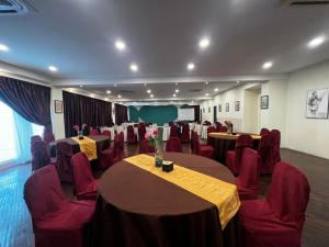 a conference room with tables and chairs and a screen at The Elopura Hotel in Sandakan